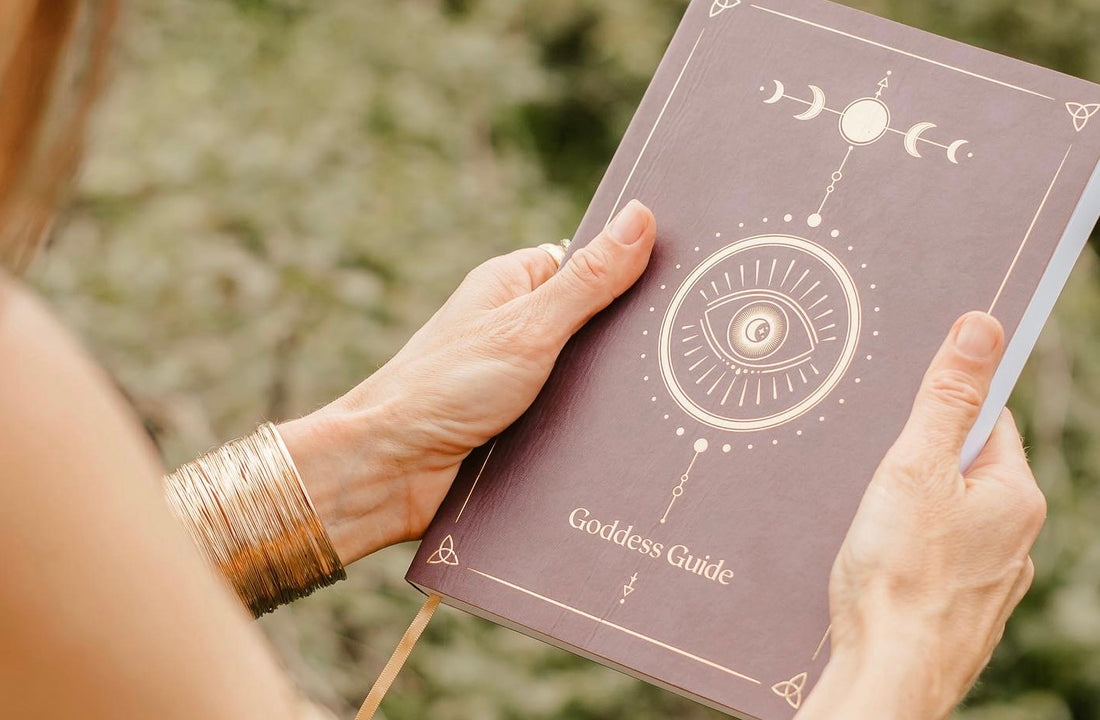 The front cover of the Goddess Guide Life Planner. Showing the Triquetra symbol, the triple goddess symbol, the moon cycle symbolising feminine energy and life circles.